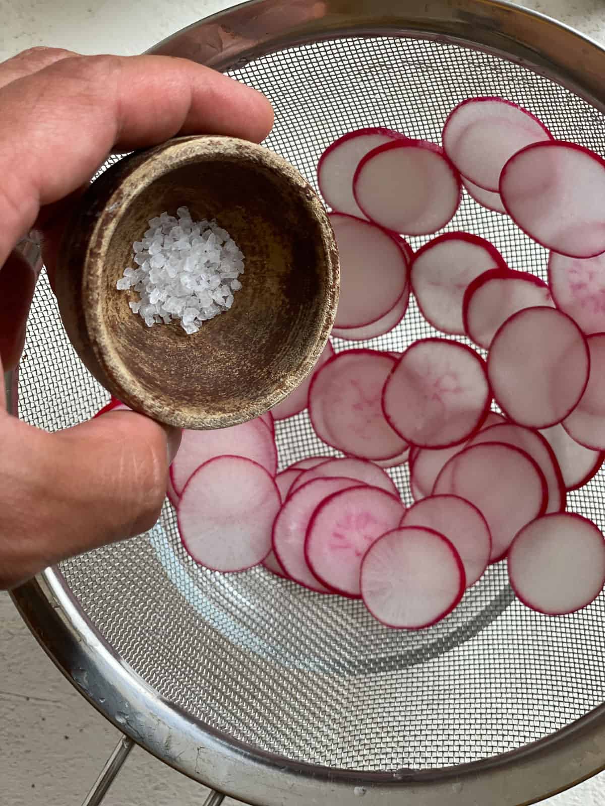 process shot of adding salt to radishes