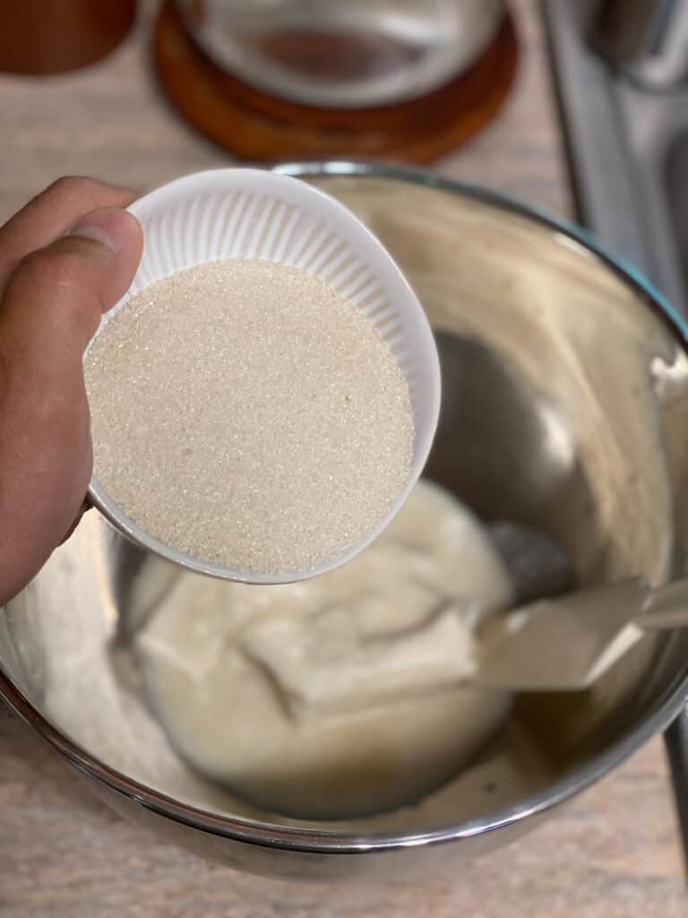 process shot of adding sugar to bowl