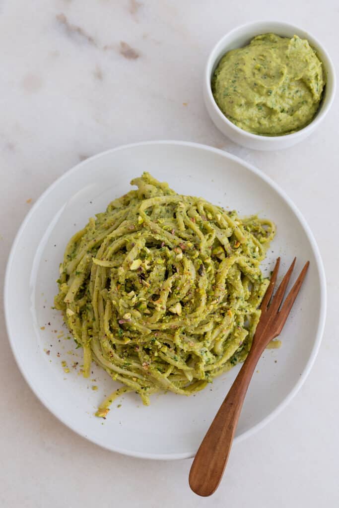 completed avocado pesto plated on a white plate against a white background