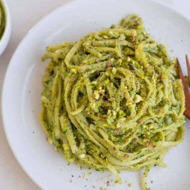 completed avocado pesto plated on a white plate against a white background