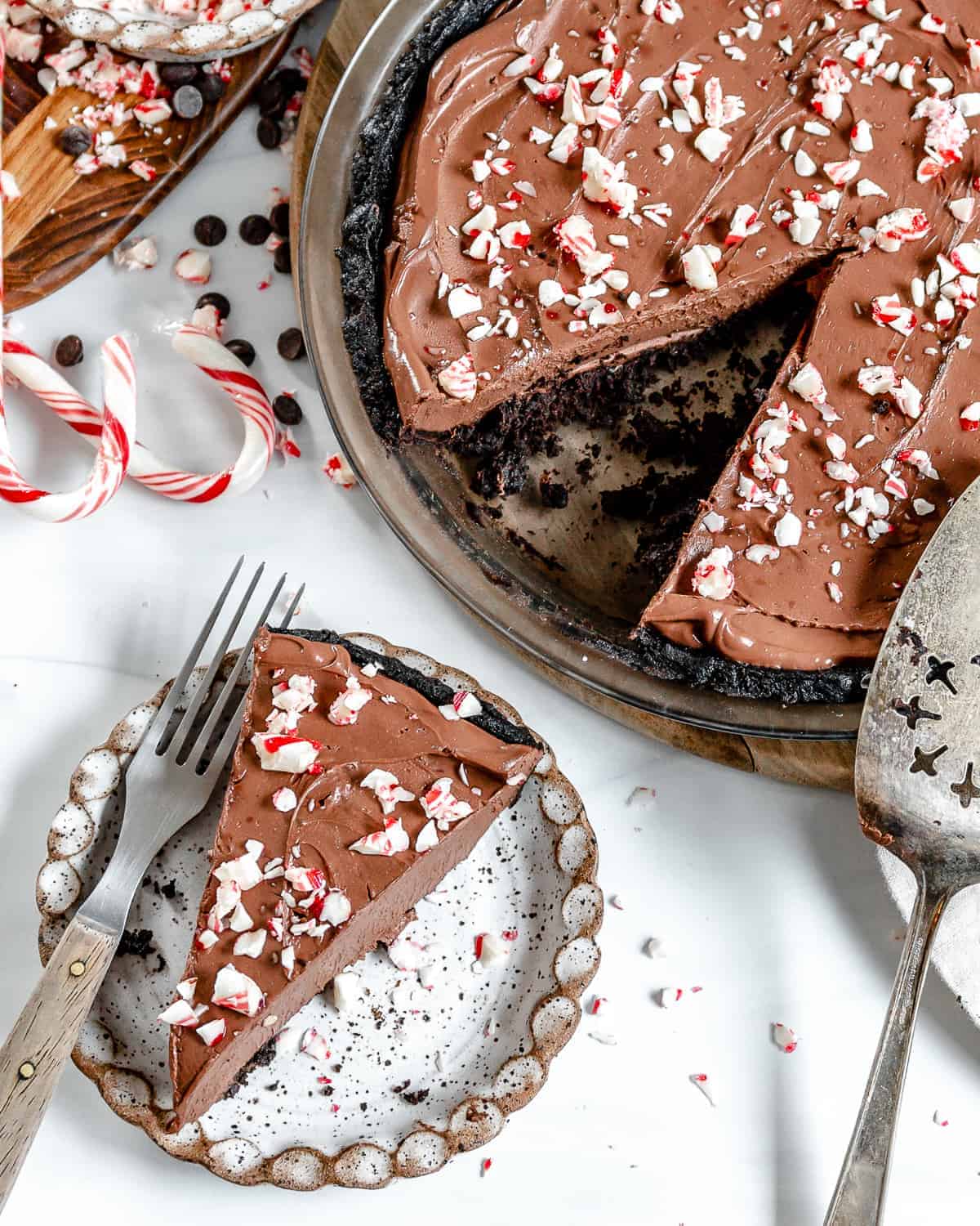 Complete slice of Silken Chocolate Peppermint Pie plated with more pie in the background.