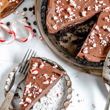 completed slice of Silken Chocolate Peppermint Pie plated with more pie in the background