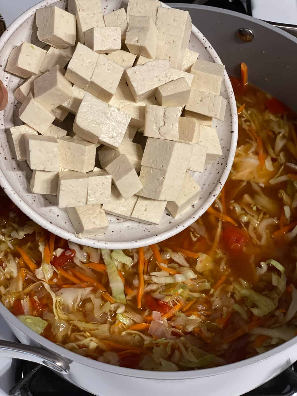 process shot of adding tofu to pan
