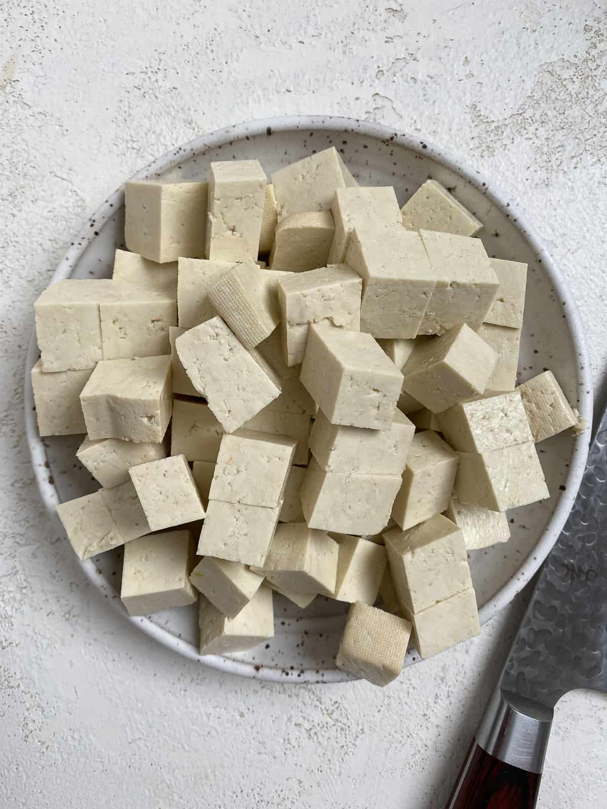 cubed tofu in a white plate against a white background
