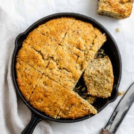 completed Vegan Cornbread Recipe in a Cast Iron Skillet against a white background