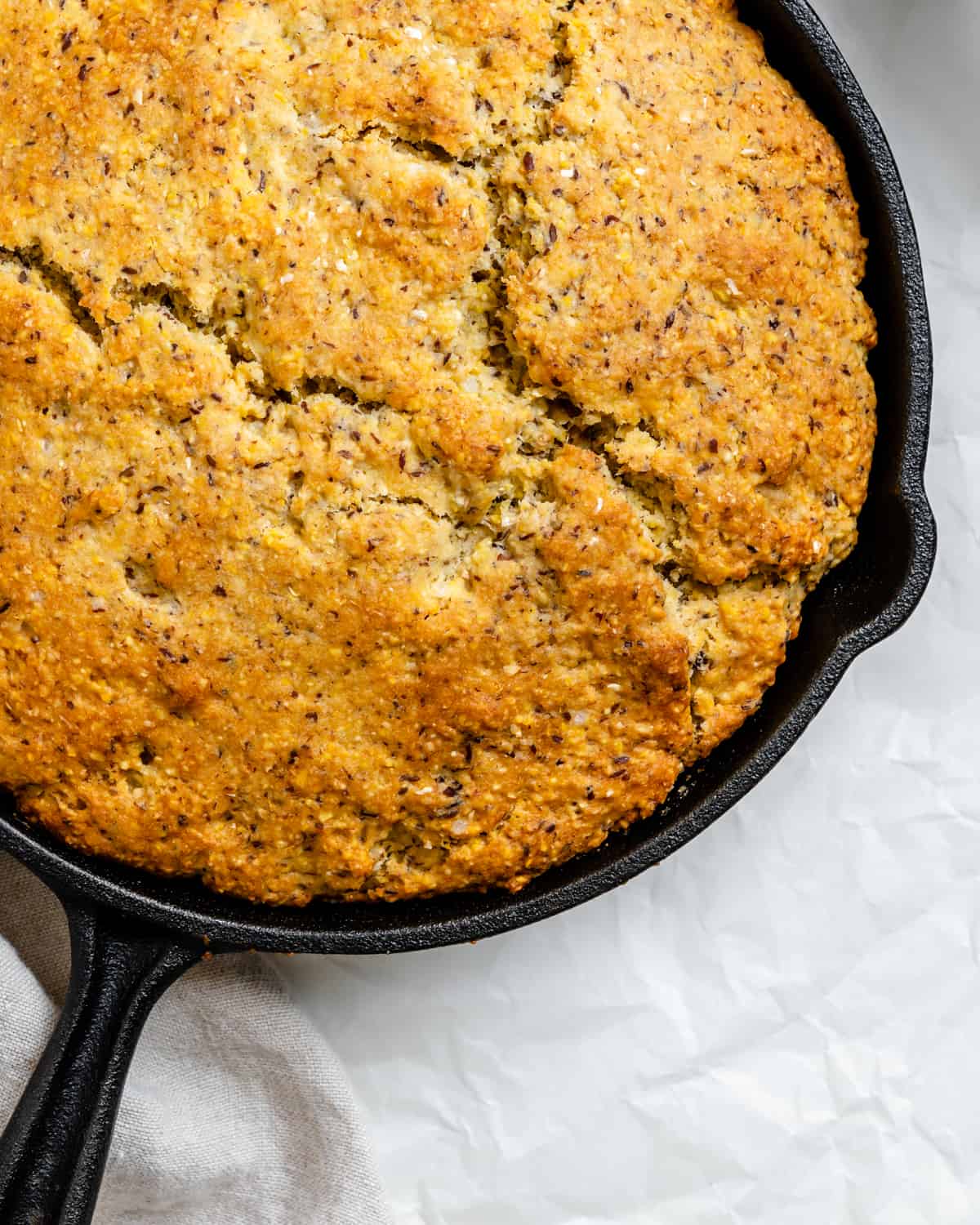 completed Vegan Cornbread Recipe in a Cast Iron Skillet against a white background