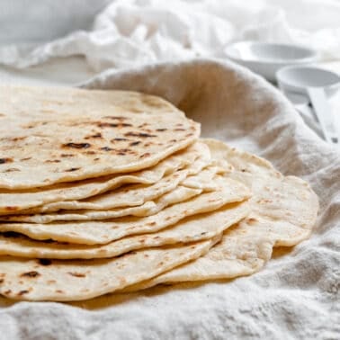 completed Tortillas de Harina – Handmade Flour Tortillas stacked on one another against a white surface