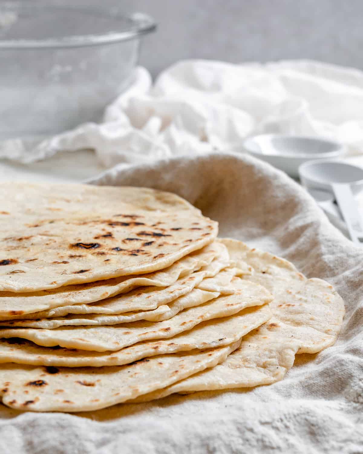ολοκληρωμένες Tortillas de Harina – Χειροποίητες τορτίγιες από αλεύρι στοιβαγμένες η μία πάνω στην άλλη σε μια λευκή επιφάνεια