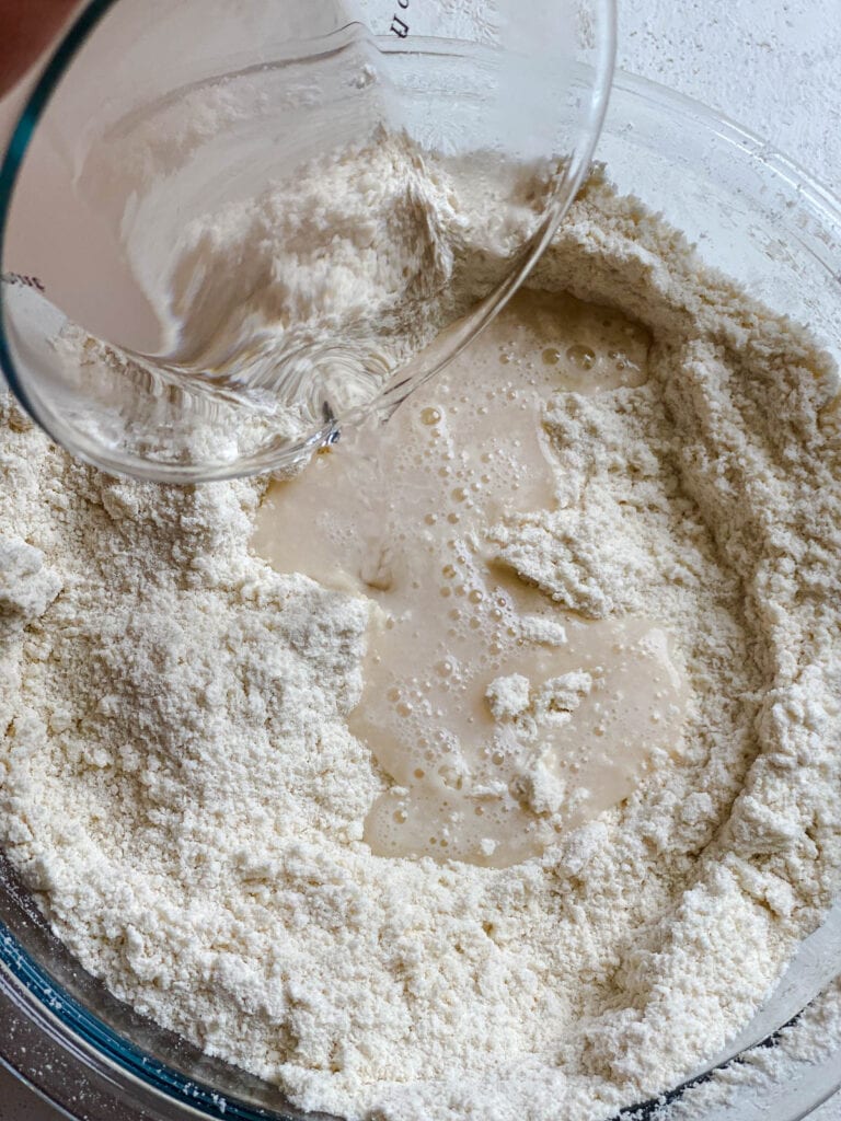 process shot of adding liquid salt mixture to dry ingredients in bowl