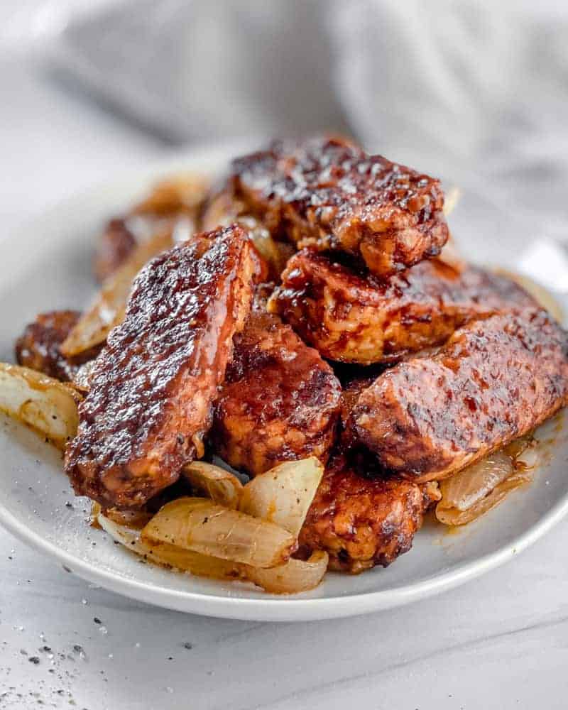 completed bbq tempeh plated on a white plate against a light background