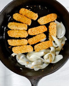 process showing cooking tempeh and onion on a pan