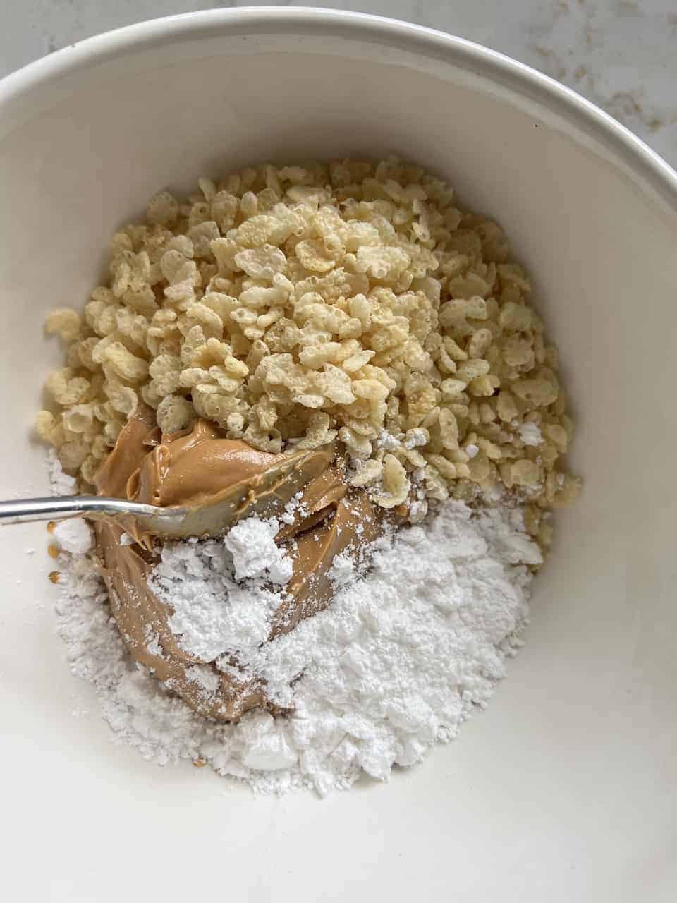 process of mixing ingredients for Peanut Butter Bon Bons together in a bowl