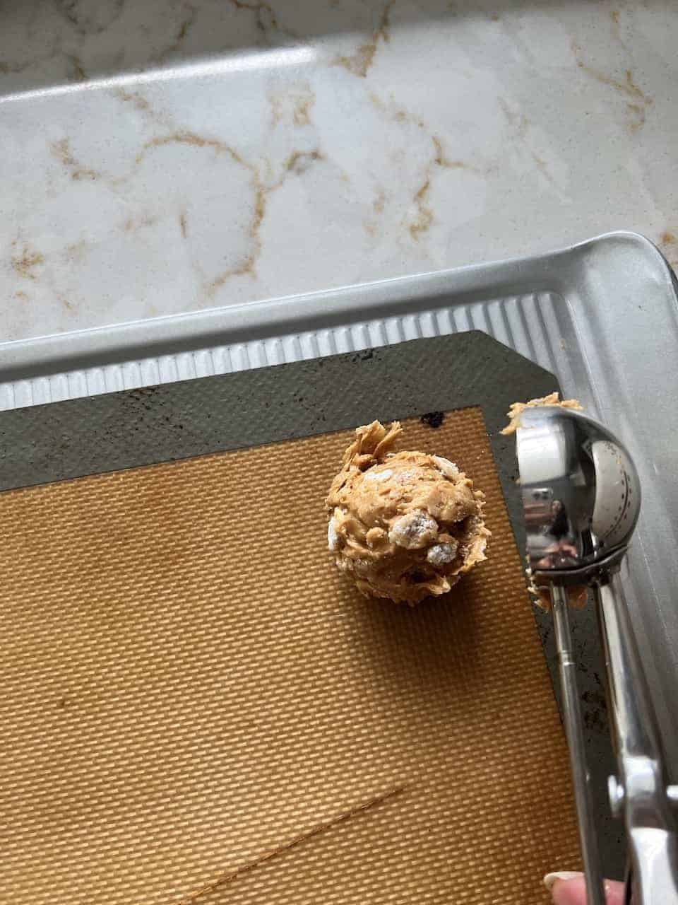 process of putting a scoop of Peanut Butter Bon Bon on a silicone mat