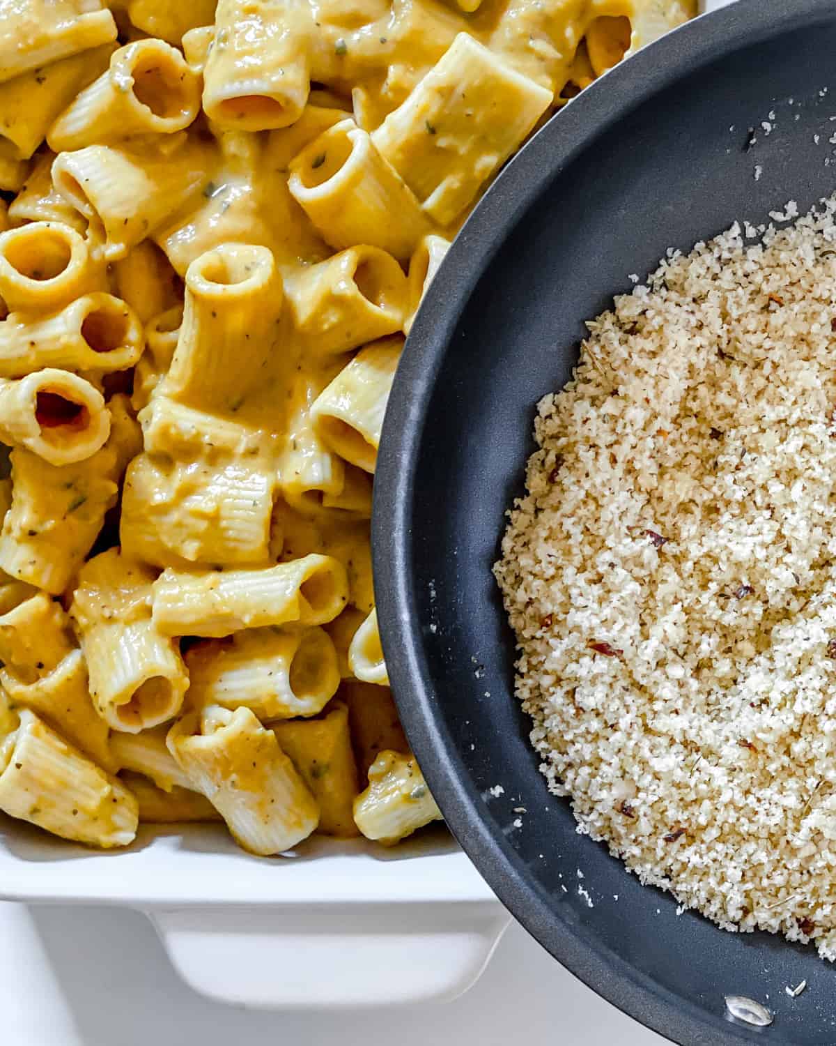 Buttery panko bread crumbs being sprinkled over the pumpkin pasta.
