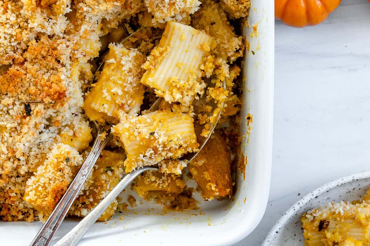 completed vegan pasta bake in a white dish with utensils in the dish