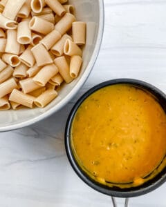 process showing Pumpkin Pasta Bake sauce in a bowl and pasta in another bowl