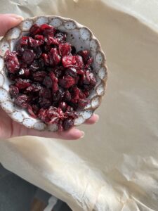 process of adding cranberries to parchment paper laid tray