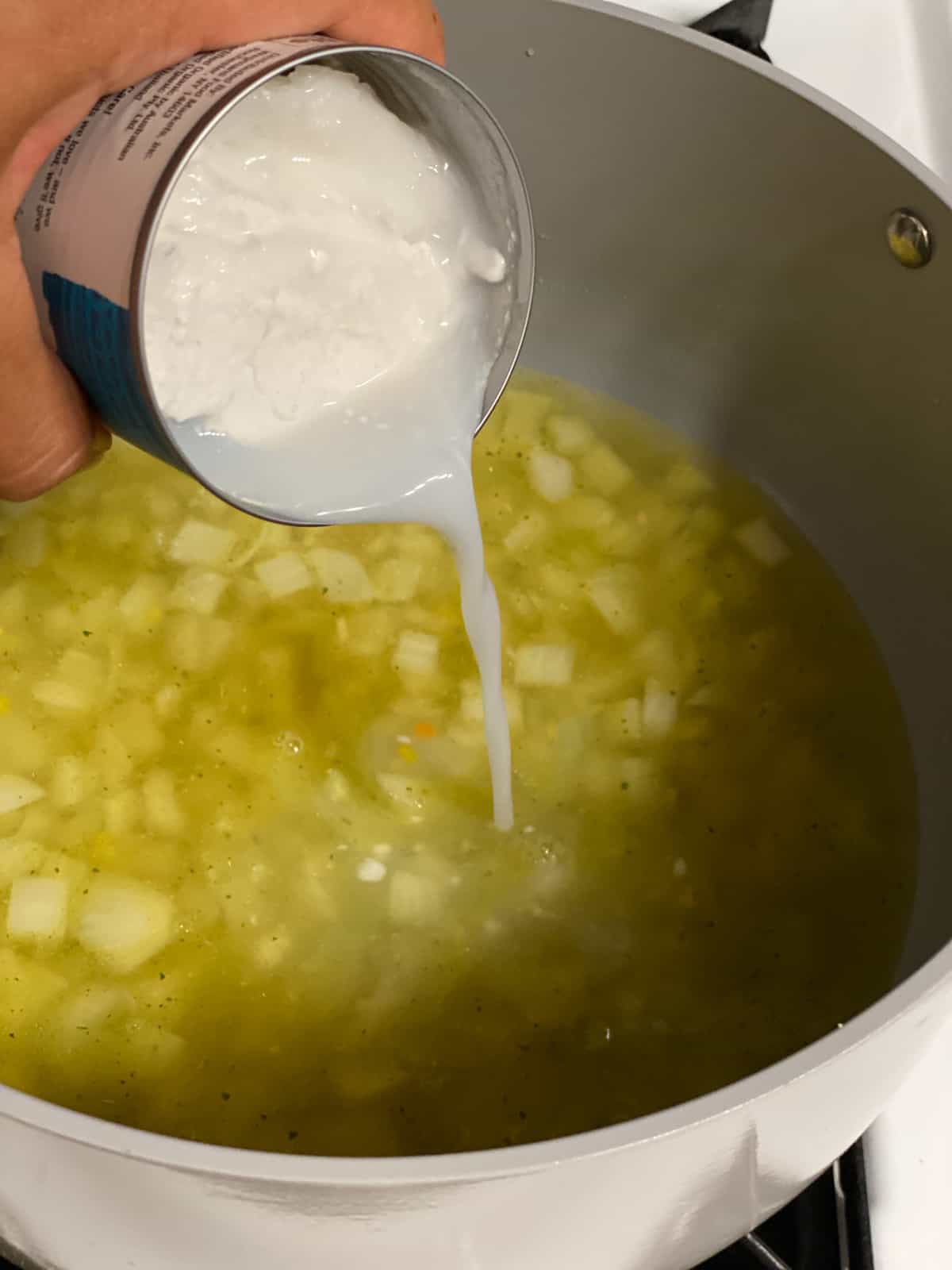 process shot of adding coconut milk to pan