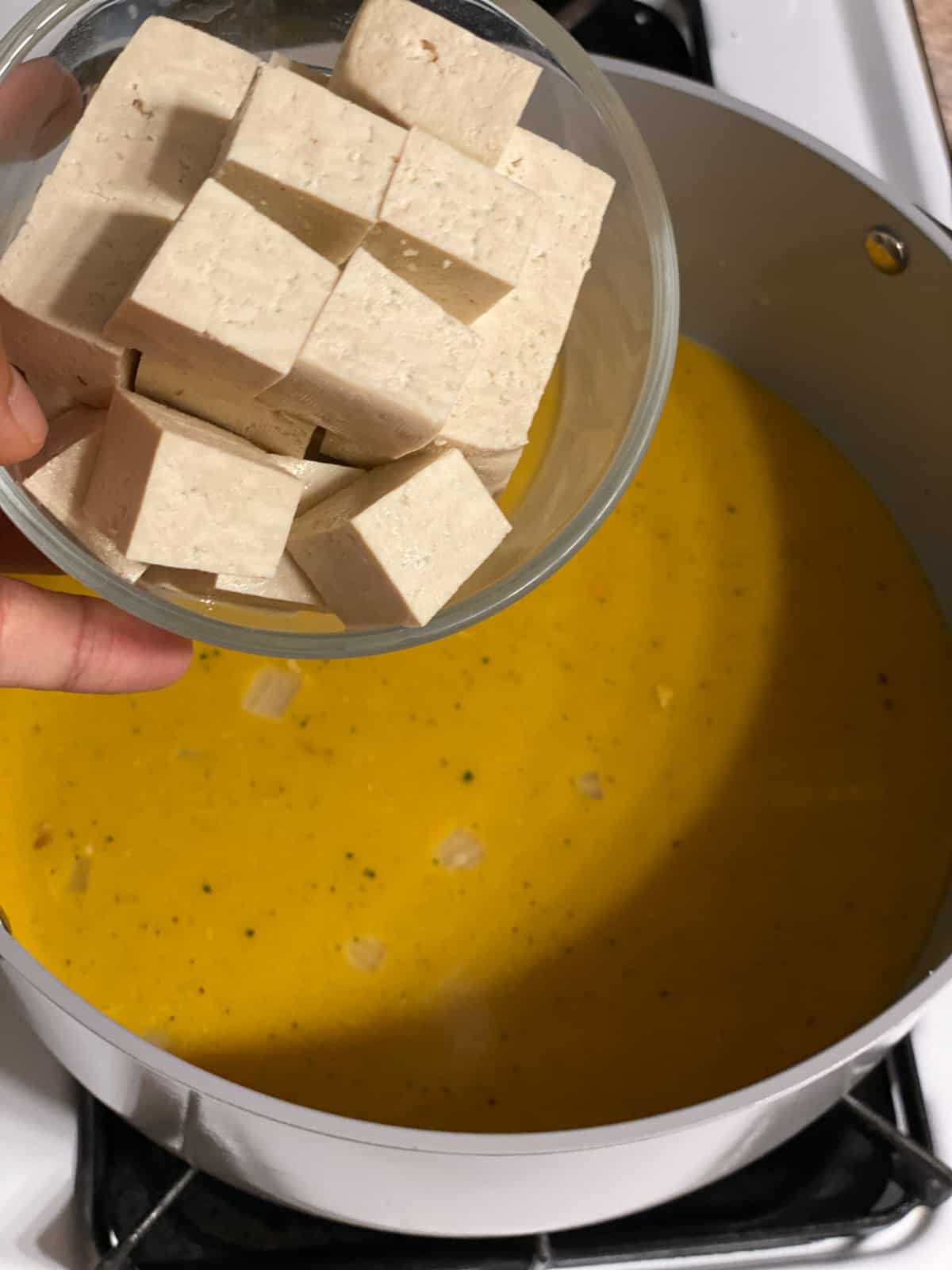 proces shot of adding tofu to pan