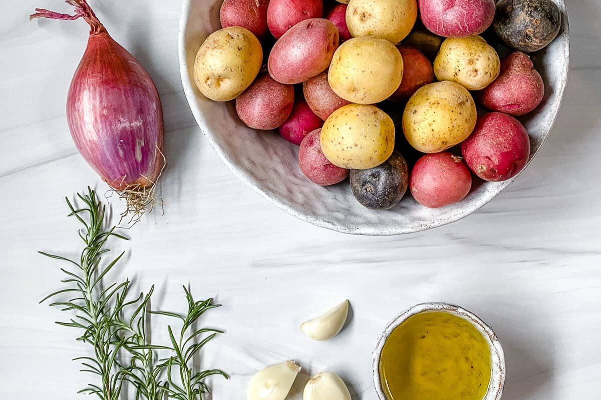 ingredients for Roasted Rosemary Potatoes measured out against a white surface
