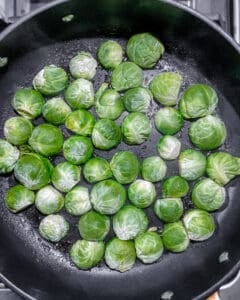 process of adding brussels sprouts to pan