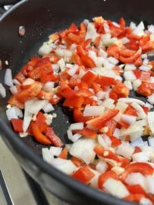 process of chopped veggies cooking on a black pan
