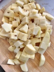 cut up potatoes on a brown cutting board