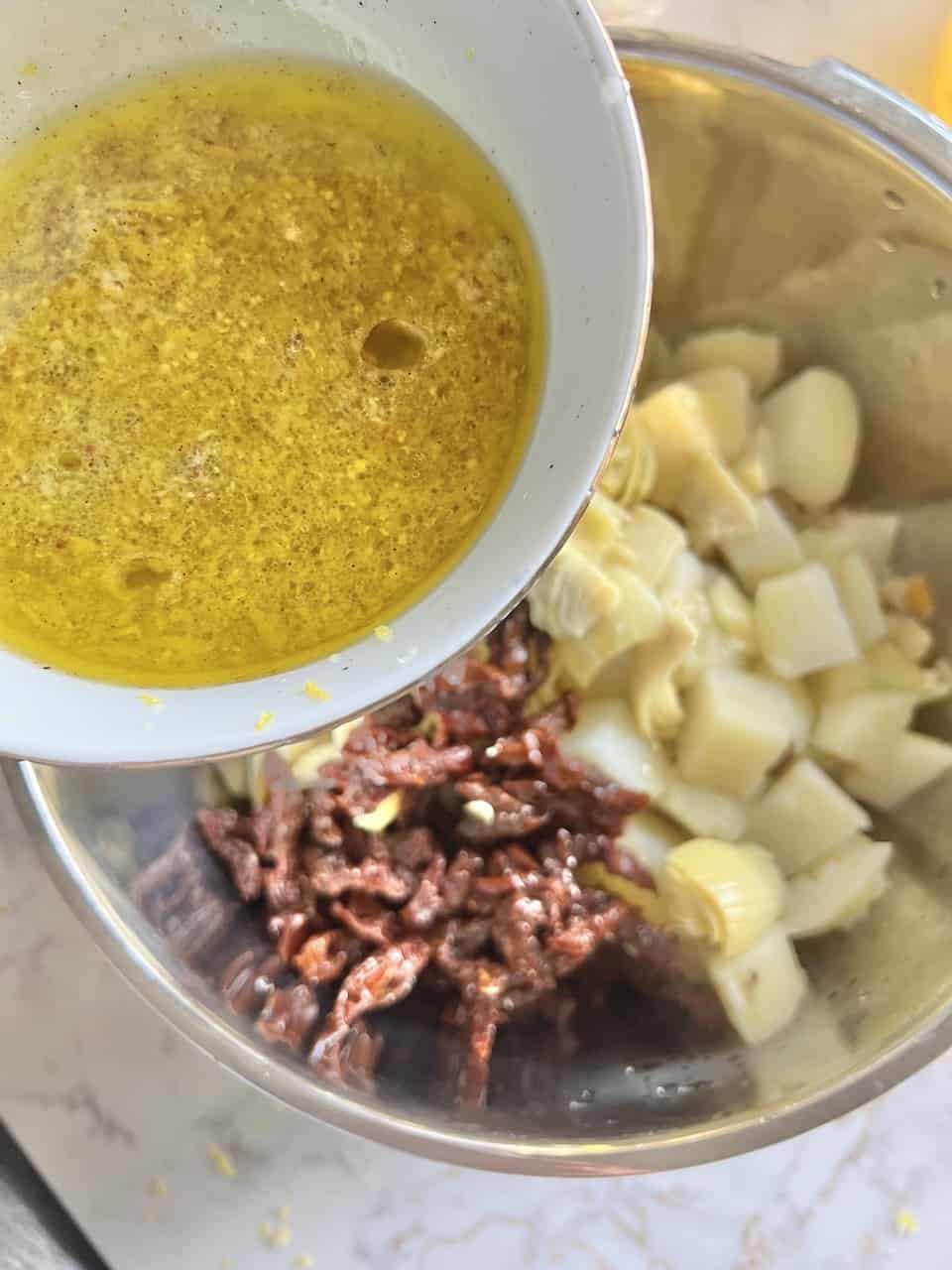 process of adding dressing to ingredients in large bowl