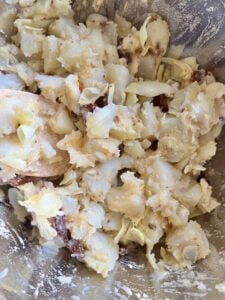 a combination of the dressing and Artichoke Potato Salad with Lemon Dressing ingredients in bowl