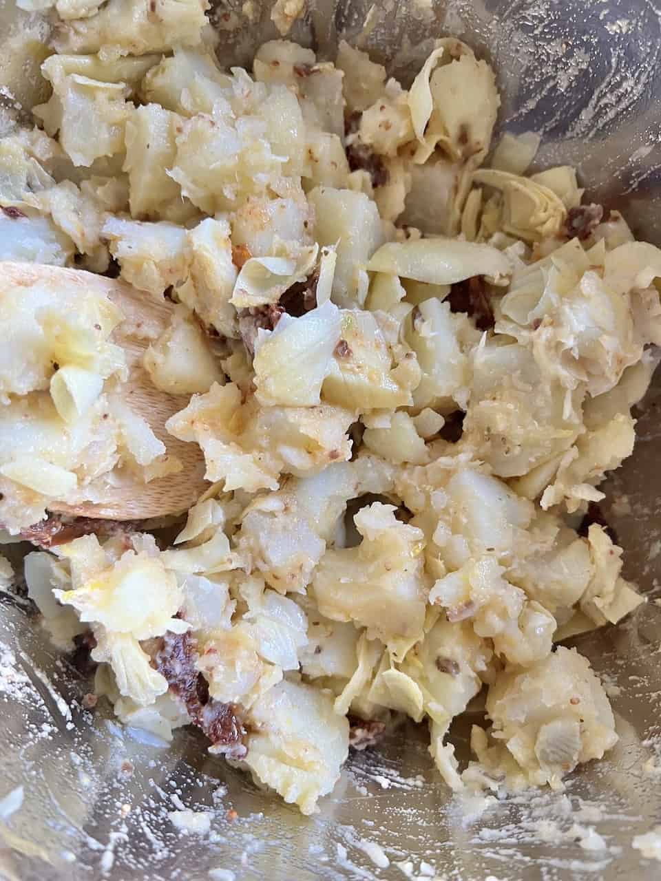 a combination of the dressing and Artichoke Potato Salad with Lemon Dressing ingredients in bowl