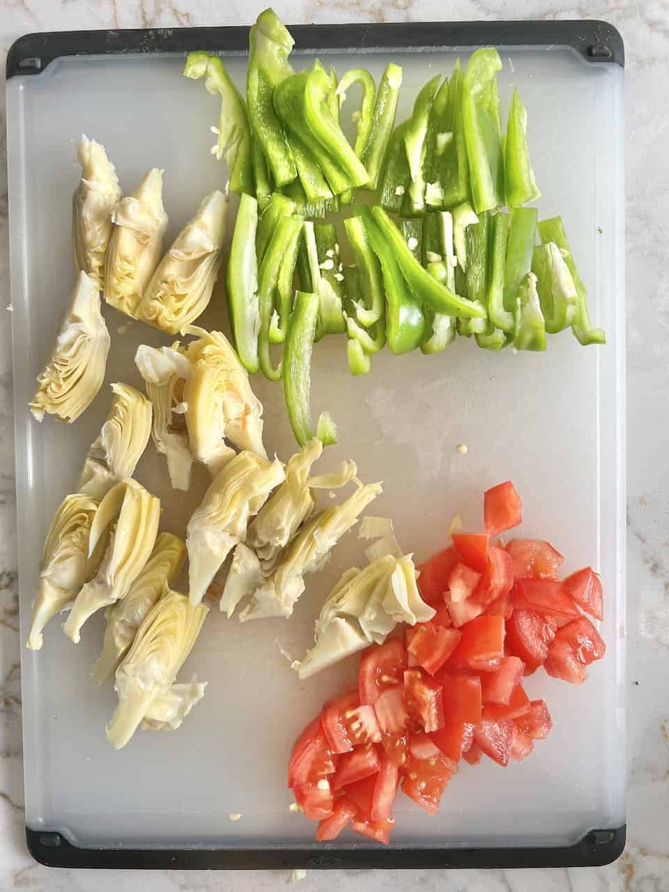 hummus pizza ingredients cut up on a cutting board