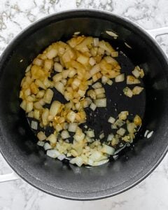 onions, garlic, and oil in a black pot