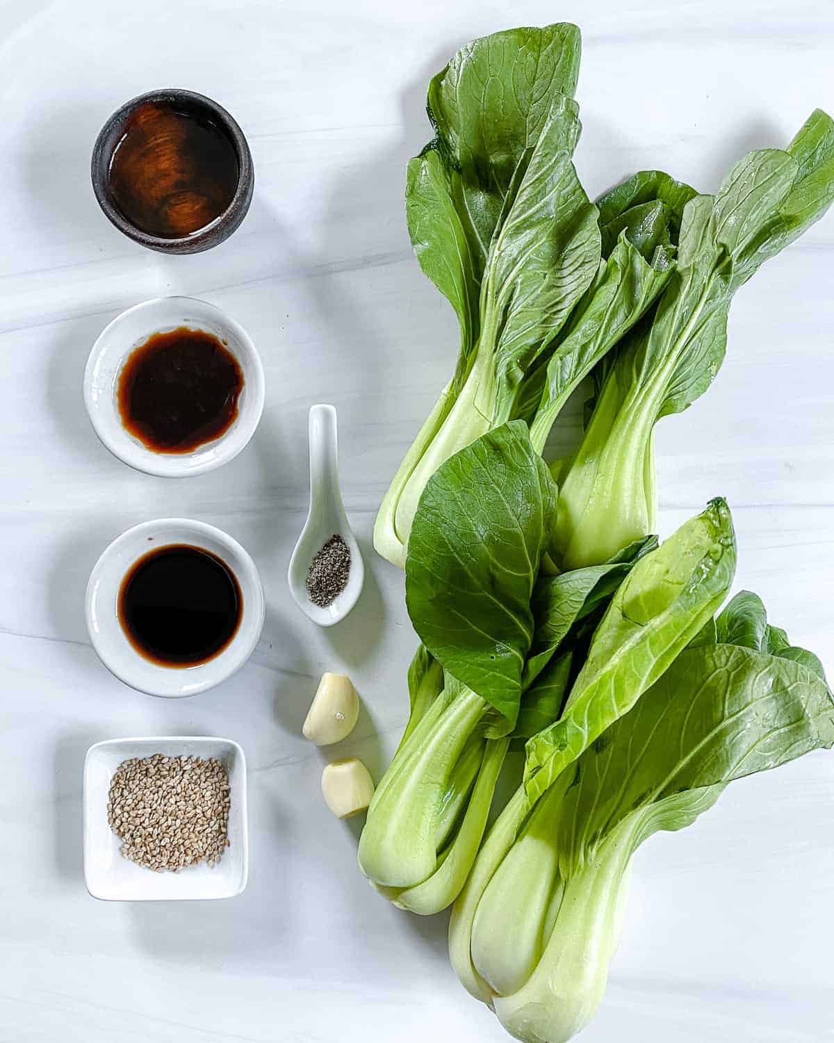 ingredients for Baby Bok Choy with Soy Sauce and Garlic measured out against a white surface