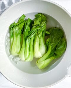 baby bok choy in a white bowl of ice water