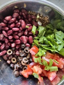 process of mixing veggies and beans to farro