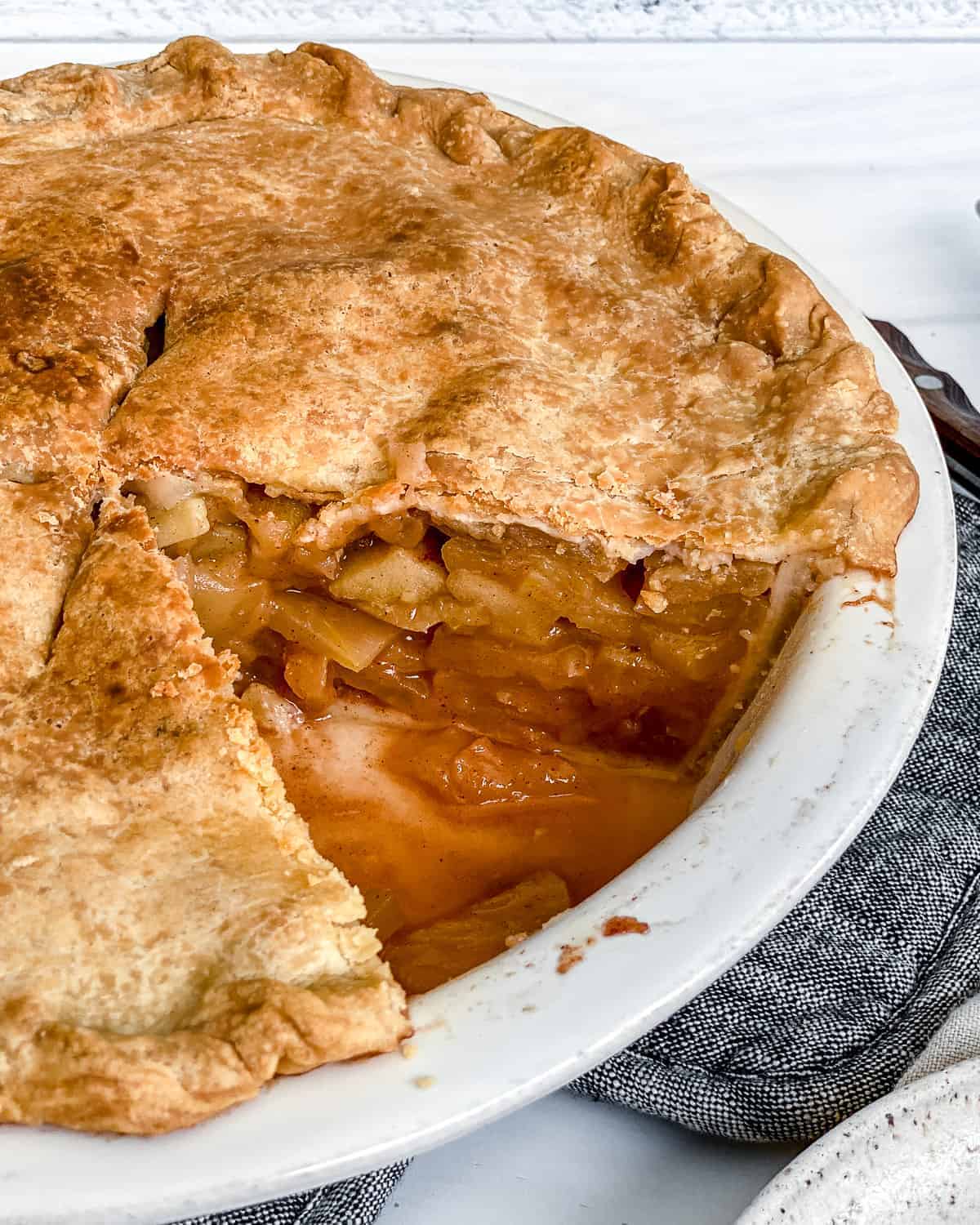 completed Vegan Apple Pie with a piece missing in a pie dish