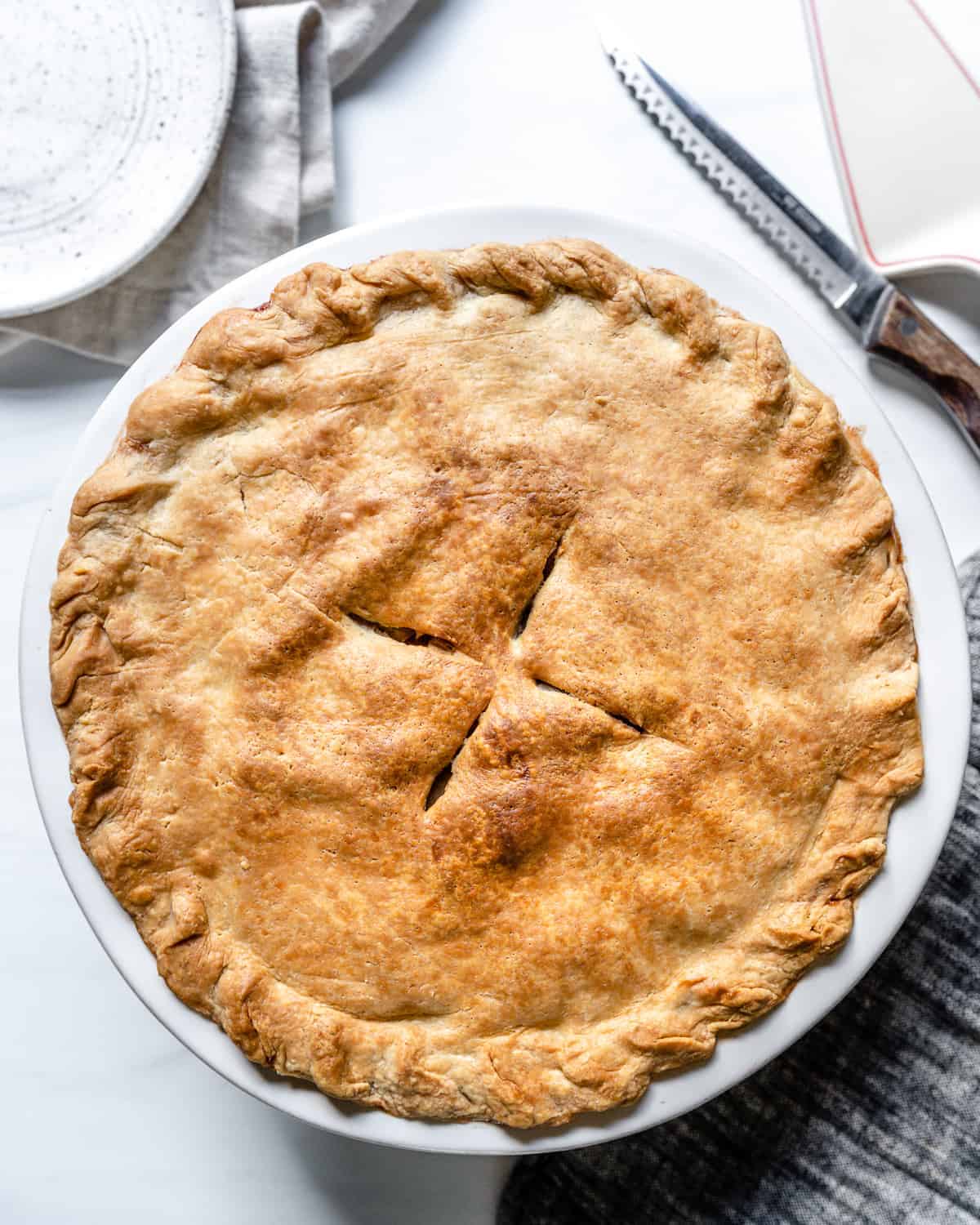 completed Vegan Apple Pie in a pie pan against a white background