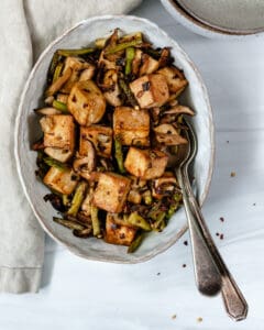 finished Shiitake Asparagus Tofu Stir-fry plated on a white plate against a white background