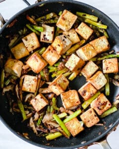 finished Shiitake Asparagus Tofu Stir-fry plated in a black pan 