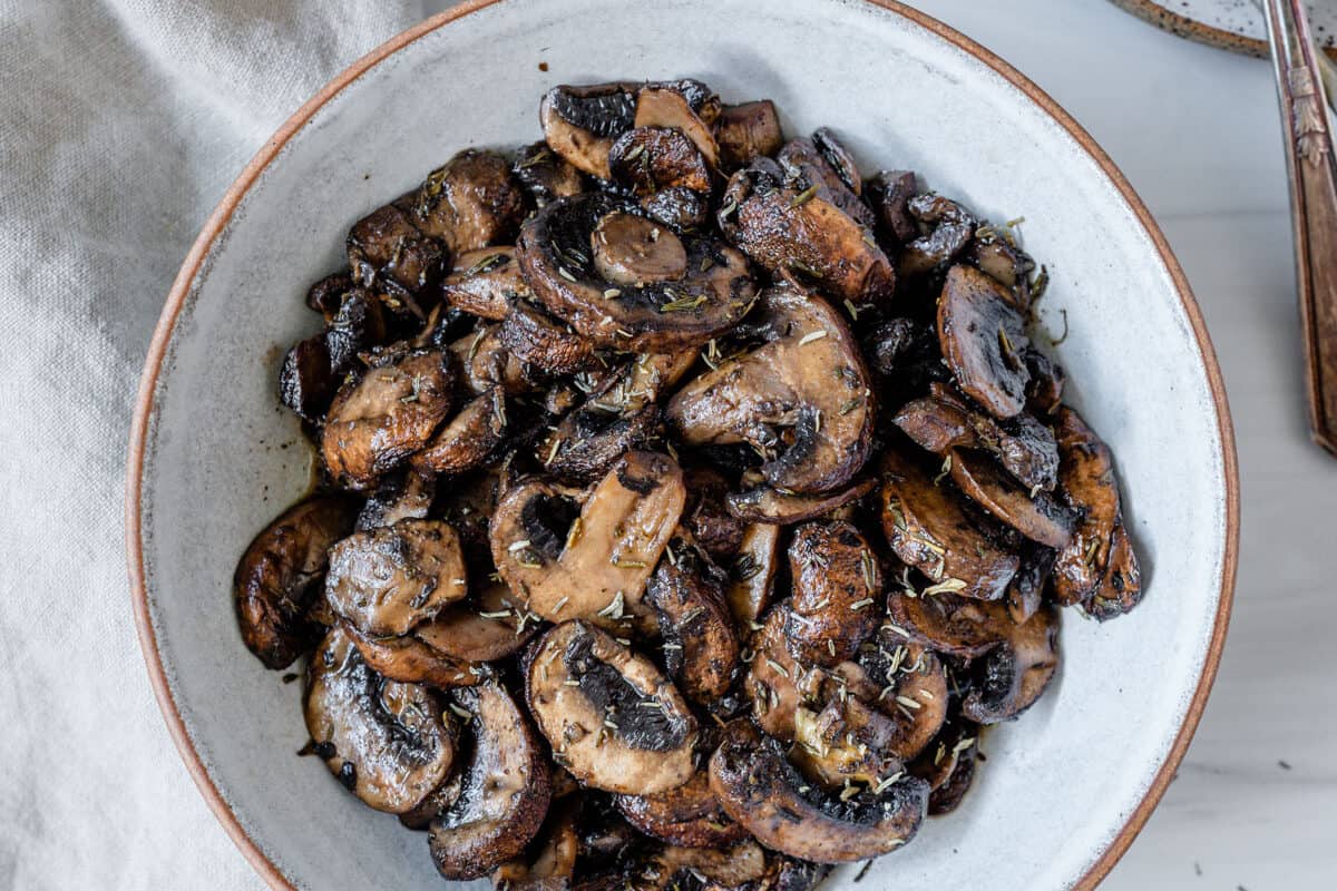 completed simple roasted mushrooms on a white plate against a white background