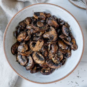completed simple roasted mushrooms on a white plate against a white background