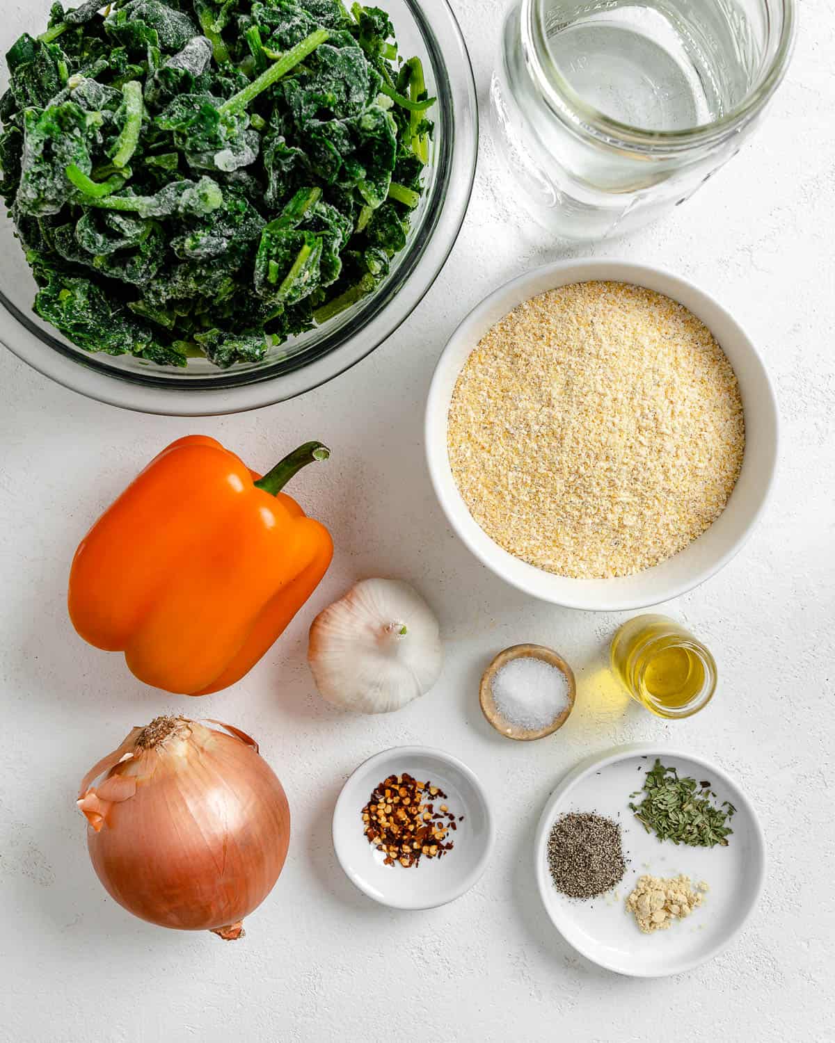 ingredients for Garlicky Spinach and Pepper Polenta Pie measured out against a white background