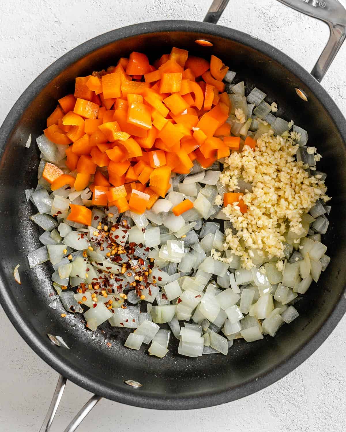 process shot of adding veggies to black pan