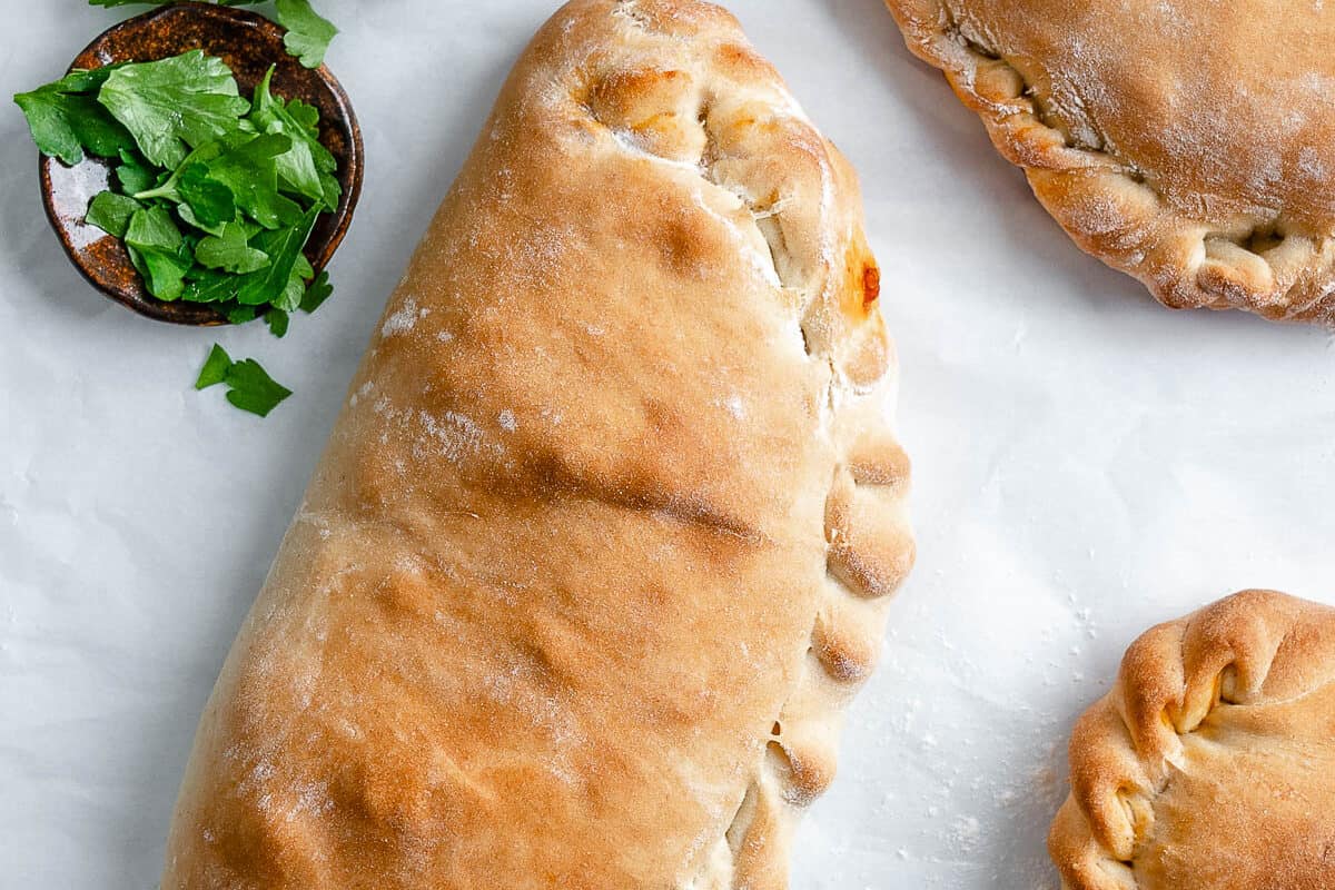 three completed completed Marinara Calzones against white surface