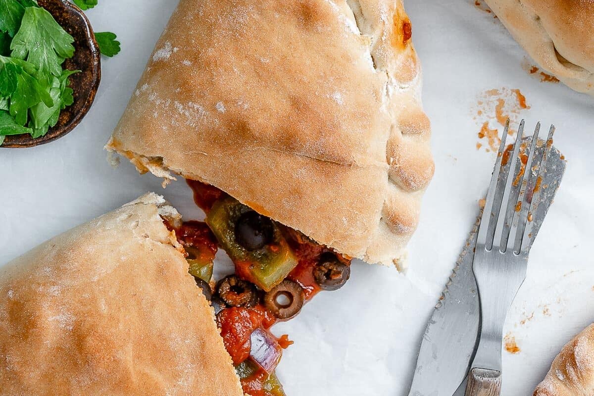 completed Marinara Calzone split open in the middle against white surface