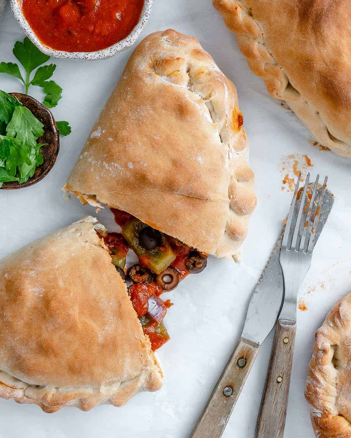 completed Marinara Calzone split open in the middle against white surface