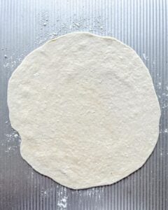 rolled out dough against gray surface