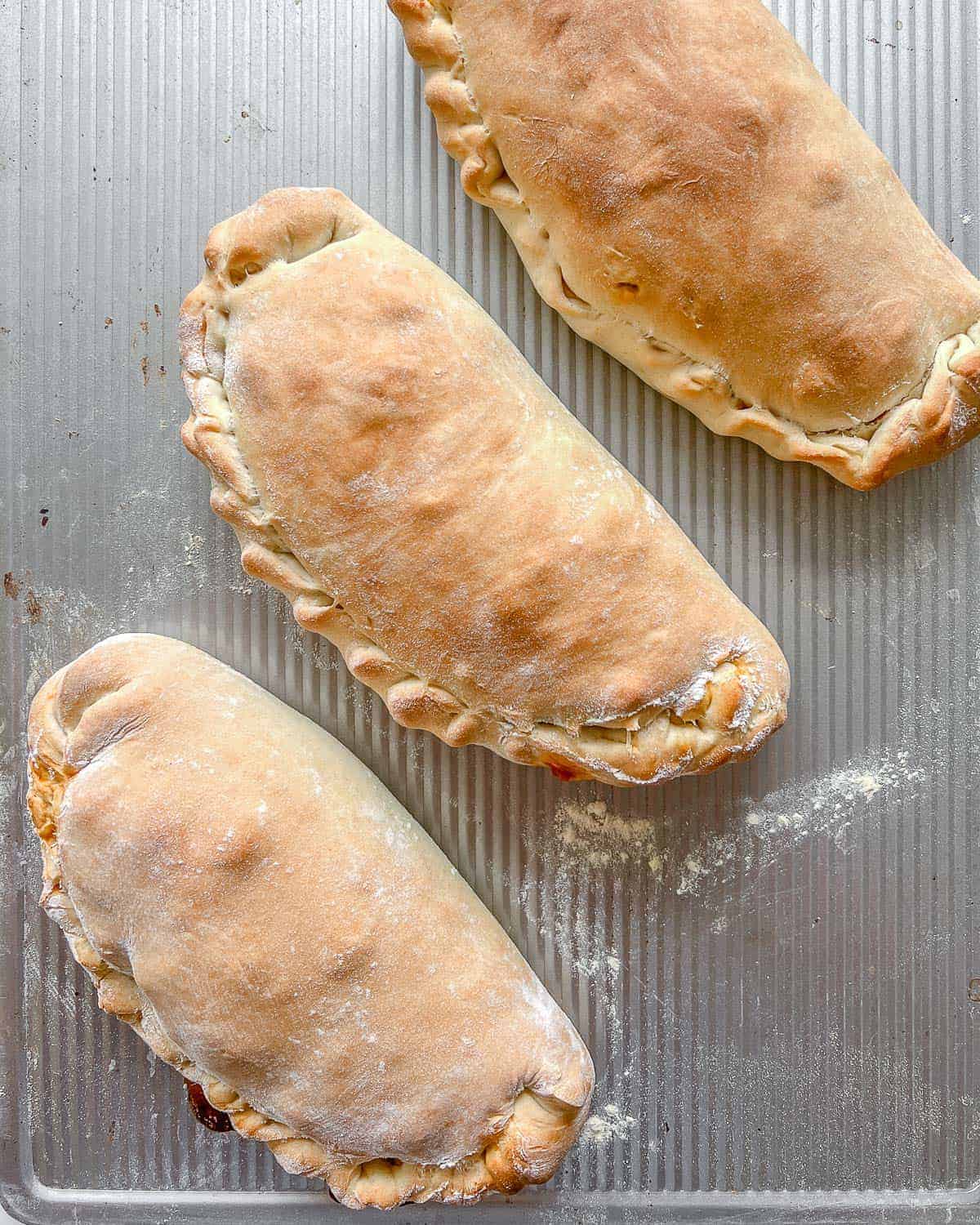 three completed Marinara Calzones on a gray surface