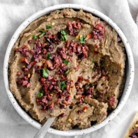 completed Spicy Lentil Kalamata Dip in a white bowl against a white background