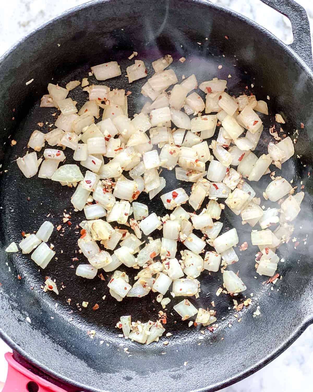 process of adding onions to black skillet